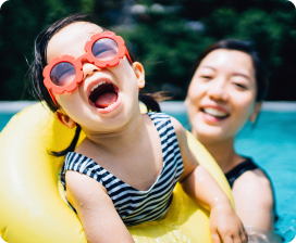 Woman and child in pool, smiling