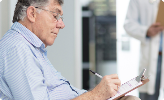 Man signing paperwork in medical office